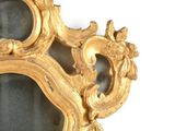 a gold mirror with a dragon on it on a white wall