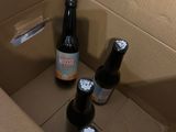 three bottles of beer in a cardboard box on the floor