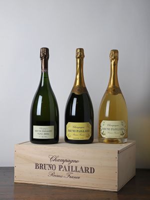 trois bouteilles de champagne dans un coffret en bois posé sur une table