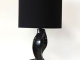 a black lamp with a red base and a black shade