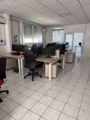 une salle avec beaucoup de bureaux et de chaises