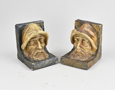 une paire de serre-livres représentant un homme coiffé d'un chapeau et un visage de femme