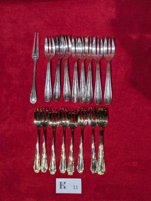 beaucoup de fourchettes et de cuillères en argent posées sur une nappe rouge