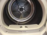 une photo d'une machine à laver dont la porte est ouverte