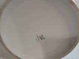 a white plate with a gold rim sitting on a white surface
