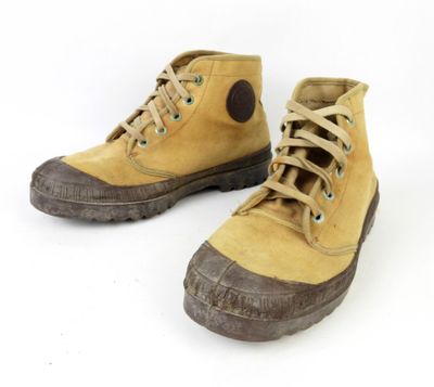 une paire de bottes jaunes à semelles marron sur fond blanc