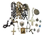 a lot of rosary and other religious items on the table