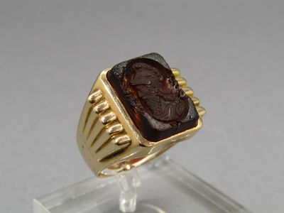 an image of a gold ring with a roman coin in the center