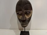 an image of a wooden mask sitting on top of a white table