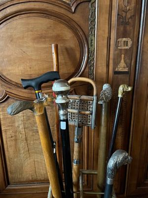 many different types of canes and walking sticks in a basket