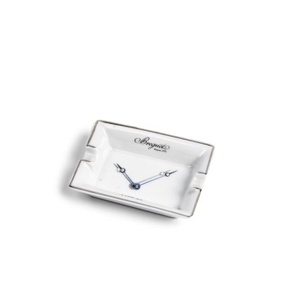 un petit cendrier carré orné d'une horloge
