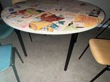 a round table with several chairs around it in a room
