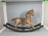 a wooden rocking horse sitting on a shelf in a room