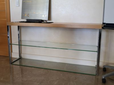 a glass shelf with a computer on top of it