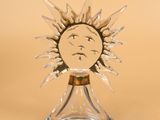 an image of a clear glass candle holder with a face on it