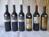six bottles of wine are lined up in a row on a table