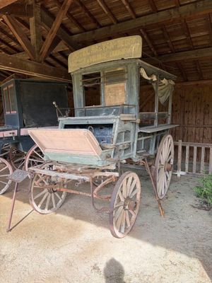 une calèche dans une grange au toit en bois