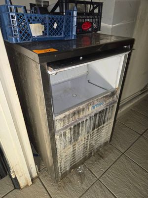 une photo d'un petit réfrigérateur dans un coin de la pièce