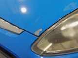 a close up of a blue car ' s headlight