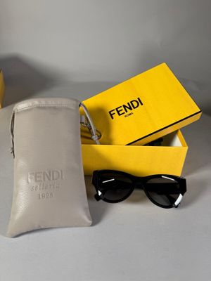 des lunettes de soleil Fendi dans un étui et une paire de lunettes de soleil posée sur une table