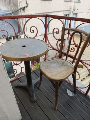 two chairs and a table on the balcony of a building