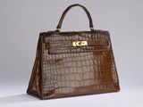 a brown crocodile skin handbag with gold hardware