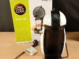 une cafetière posée sur une table à côté d'une boîte de café