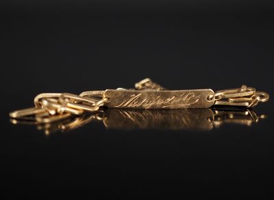 gros plan d'un collier en or sur une surface noire