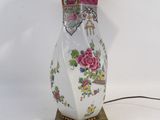 a lamp that is sitting on a stand with a pink shade