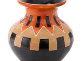 a black and orange vase sitting on a white surface