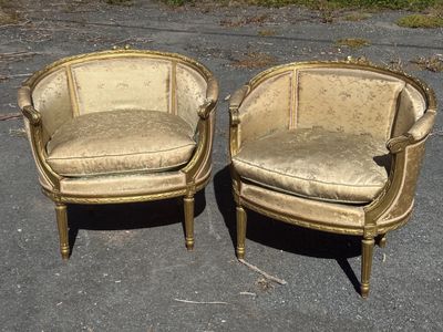 pair of antique chairs in the middle of a parking lot