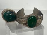un gros plan sur deux bracelets en argent ornés de pierres vertes
