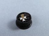 a small black button with a gold star on it
