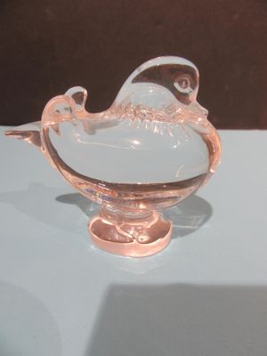 un bol en verre orné d'un oiseau, posé sur une table