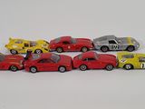 several toy cars are lined up in a row on a white surface