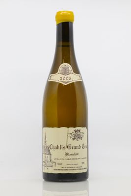 une bouteille de vin blanc posée sur une table blanche