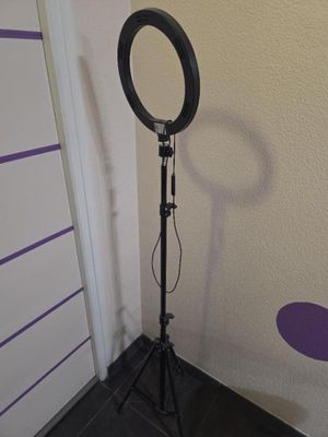 une image représentant une photo d'une lampe annulaire posée sur un trépied