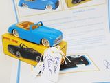 une petite voiture bleue et une petite voiture jaune posées sur un livre