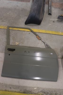 une portière de voiture peinte en argent et posée par terre
