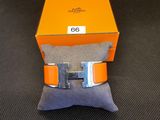 une boîte orange surmontée d'une boucle argentée, posée sur un oreiller