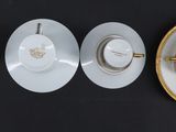 three cups and saucers sitting on a black table