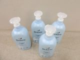 four bottles of blueberry hand sanitizer sitting on top of a table