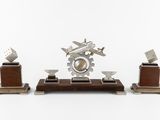a metal sculpture of a plane on a wooden stand