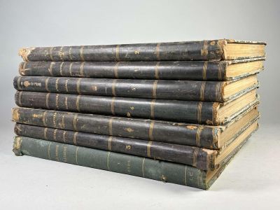 several old books stacked on top of each other on a table