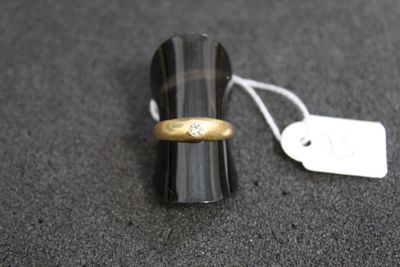 une bague en or sertie d'un diamant, à côté d'une étiquette de prix