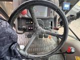 a driver ' s seat of a tractor with a steering wheel