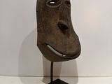 a close up of a sculpture of a face on a stand