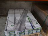 Plusieurs piles de cartons sont empilées sur une palette dans un entrepôt