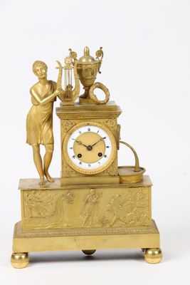 a gold clock with a statue on top of it