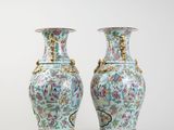 pair of vases sitting on a white surface with a white background